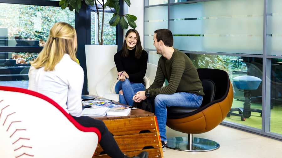 Studenten op stoelen bij lage tafel lachend meisje horizontaal