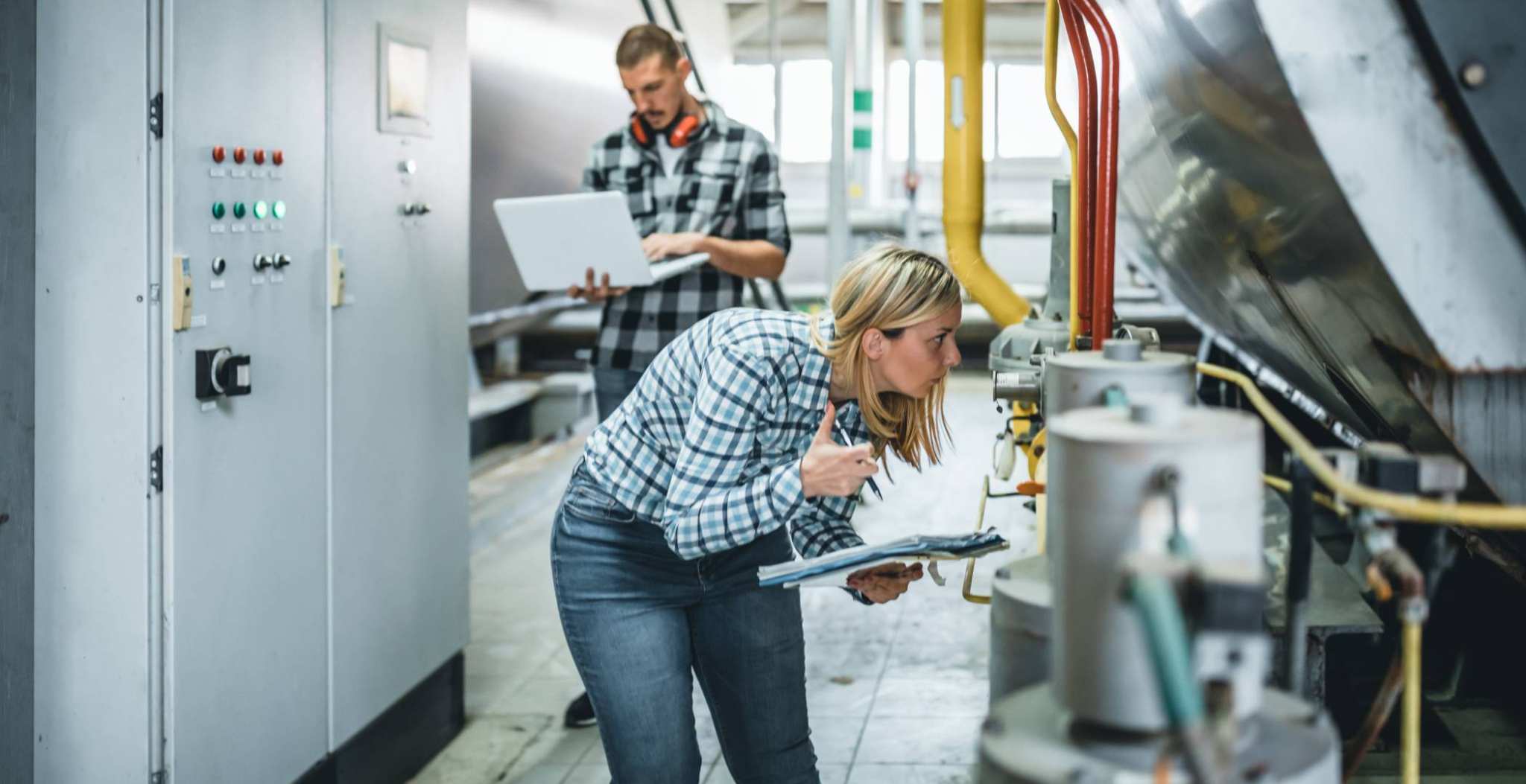 Vrouw met notitieboekje bij een hogedruk ketel. Open Avond. Bouwkunde. GGIT