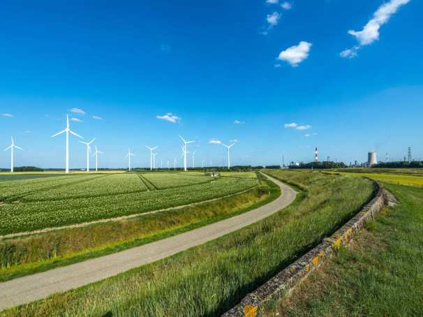 Nederlands landschap met blauwe lucht, windmolens en energiecentrale