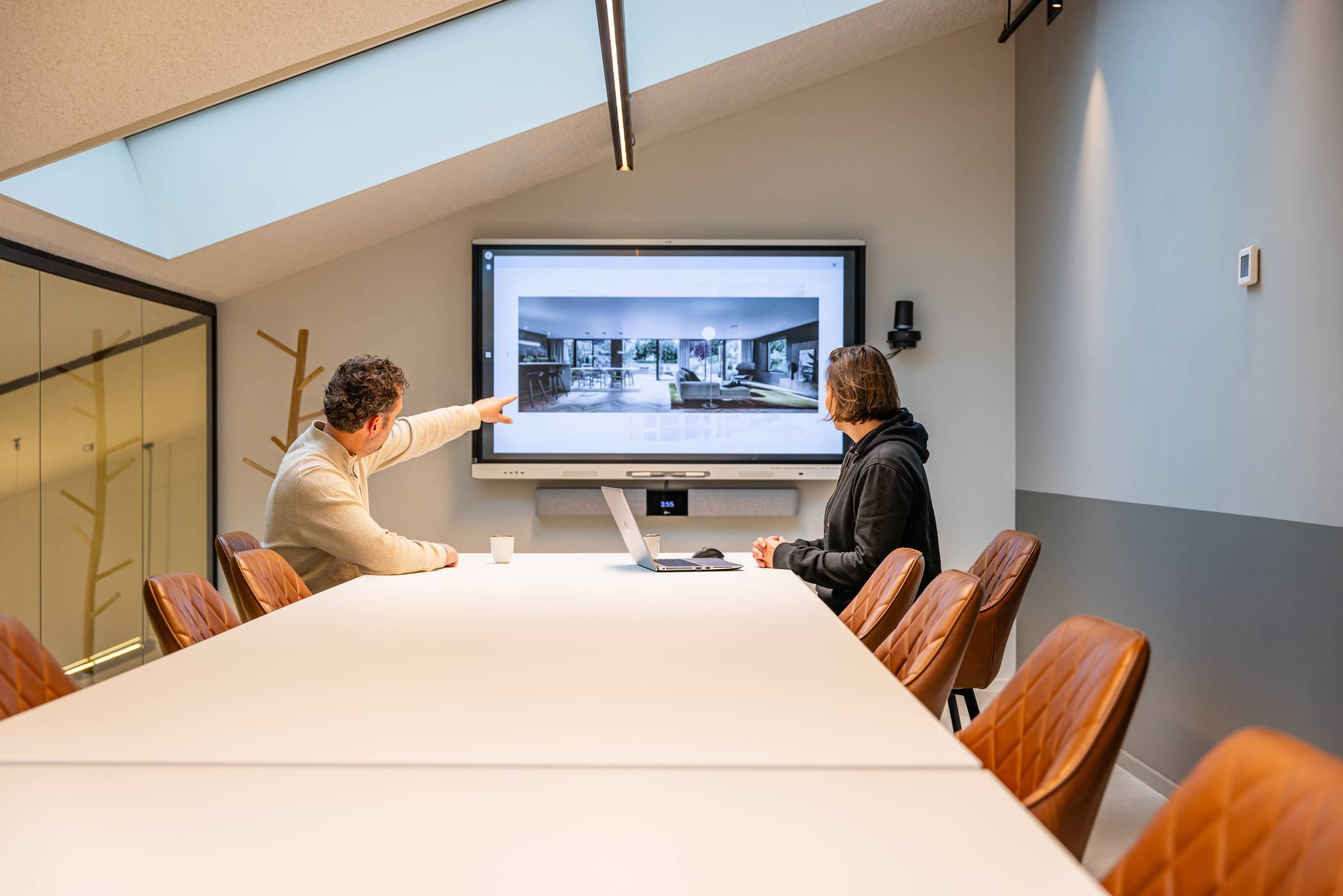 man en vrouw overleggen bij een digibord