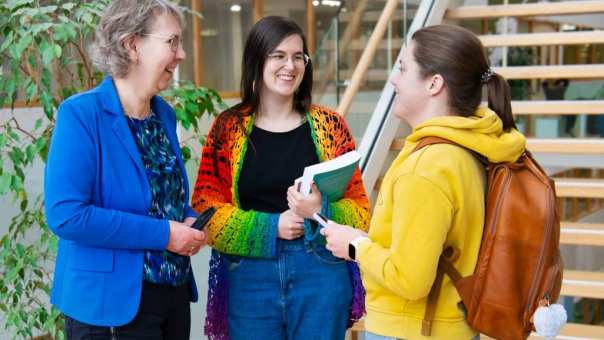 3 masterstudenten staan voor de trap op Kapittelweg 35 te praten