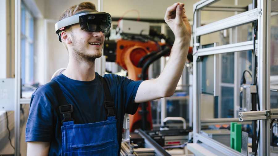 Man / student werkt met AR bril op. Virtual reality in een productieomgeving. 