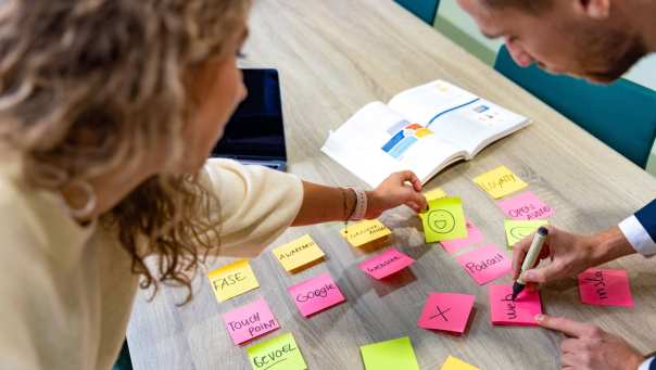 Duaal studenten Commerciële Economie werken samen aan een customer journey project met post-its.