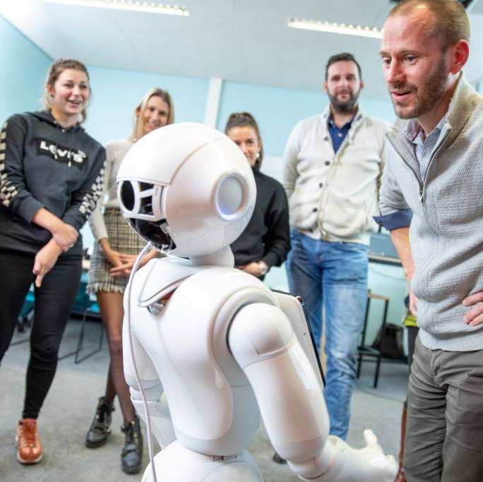 Maurice Magnée heeft interactie met een robot in het iXperium Health in het gebouw van de HAN.