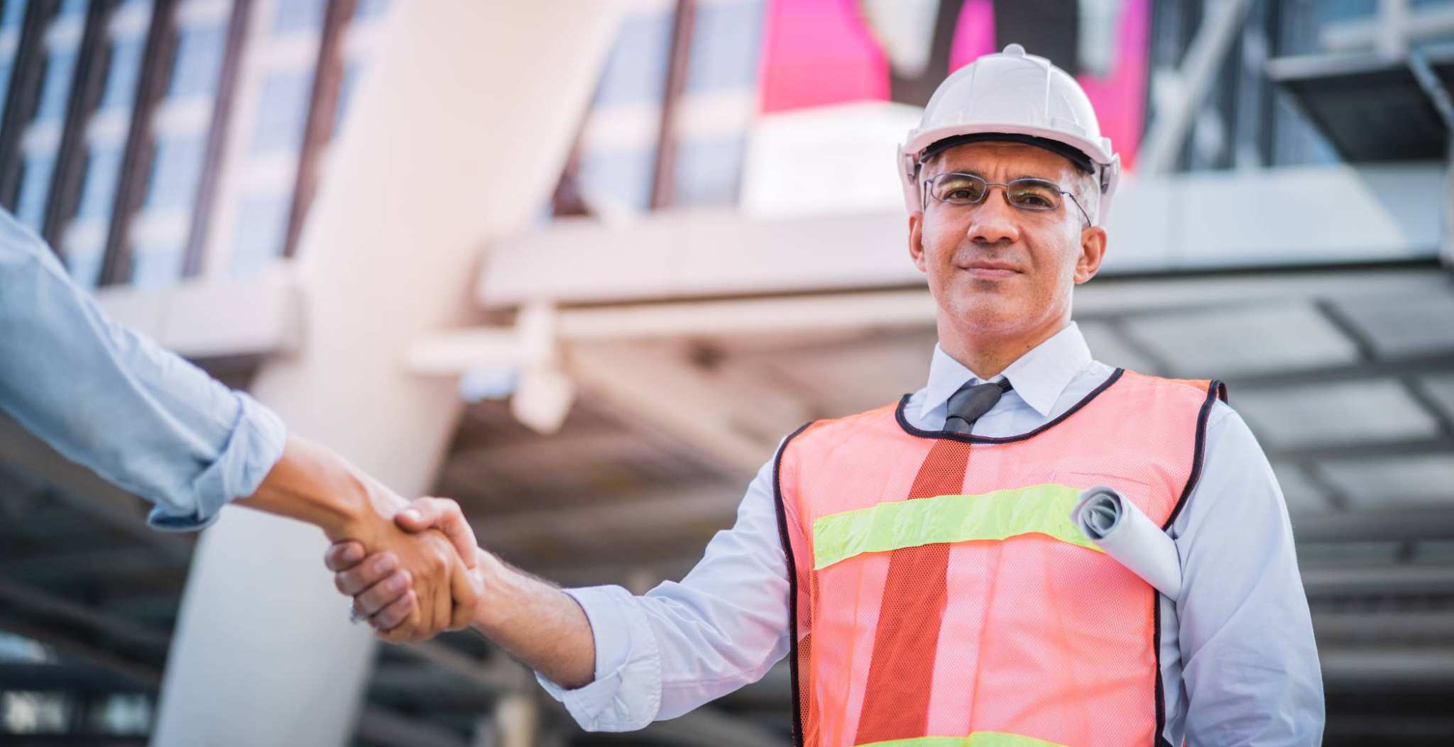 Foto van een man op de bouw die een hand geeft voor de projectenpagina van het lectoraat Financial Control. 