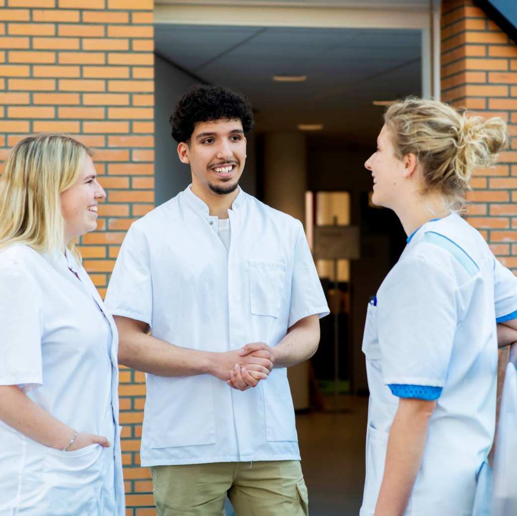 8x gezondheid studenten omarmen elkaar in een kring terwijl ze buiten op het gras staan