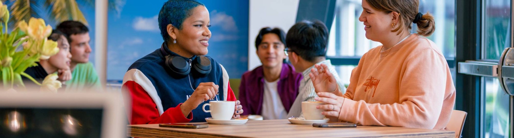 Students Noa, Chadionne, Tam, Diego, Nyugen and Andrei relaxing and drinking coffee in the Hangar on the Arnhem campus of HAN University of Applied Sciences.