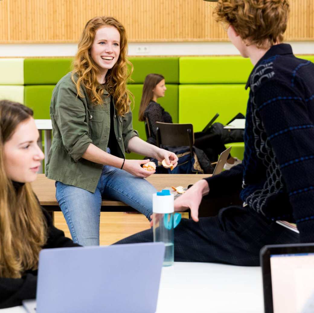 Lachende ALPO studenten met fruit en waterfles