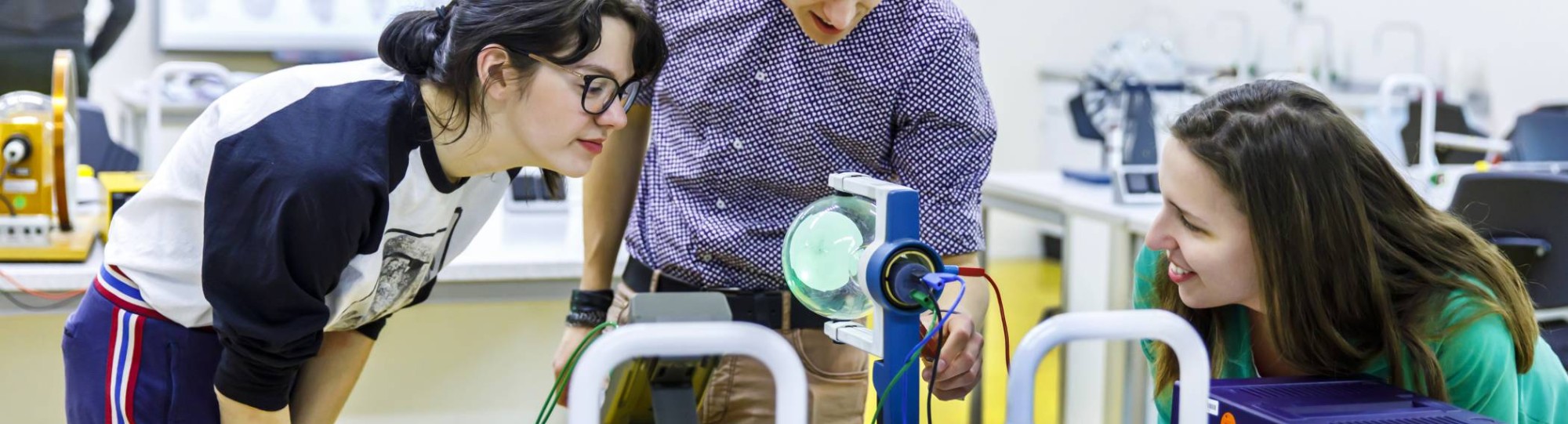 Drie studenten Leraar Natuurkunde kijken aandachtig naar hun experiment.