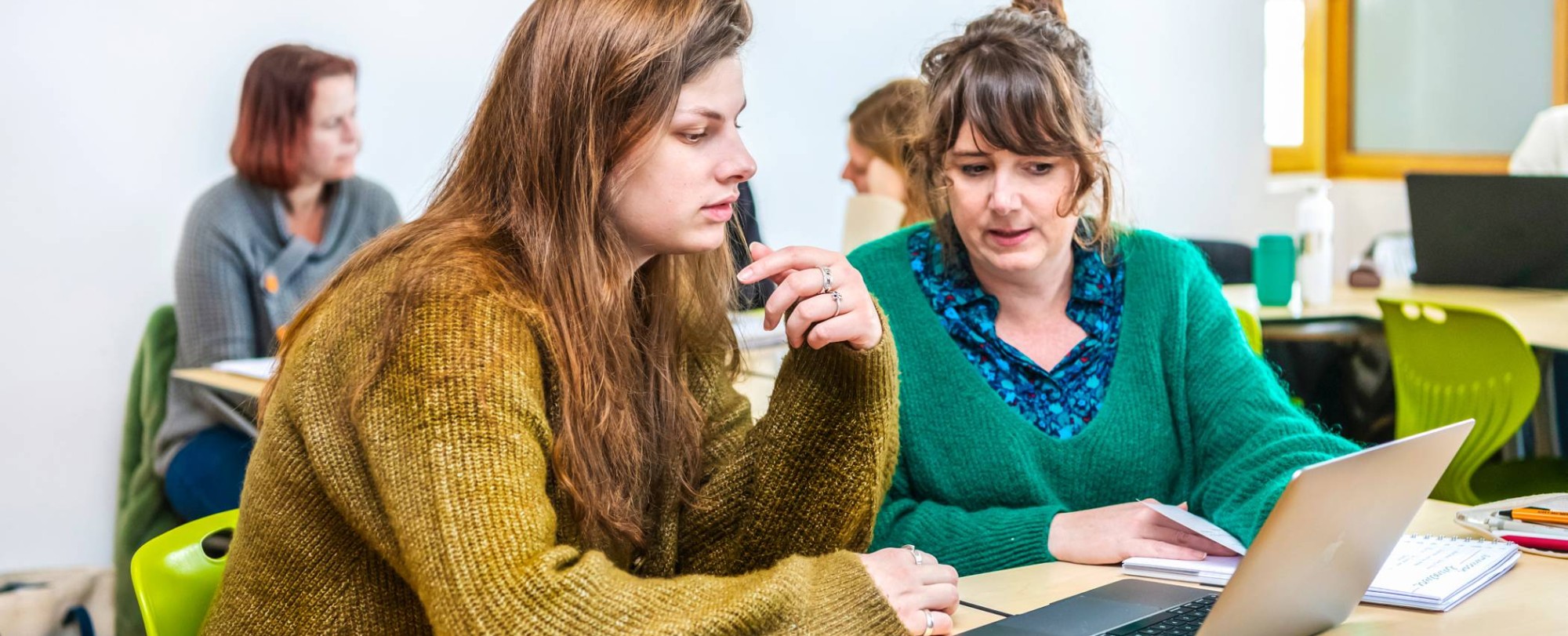 Twee studenten Leraar Engels werken samen op één laptop.
