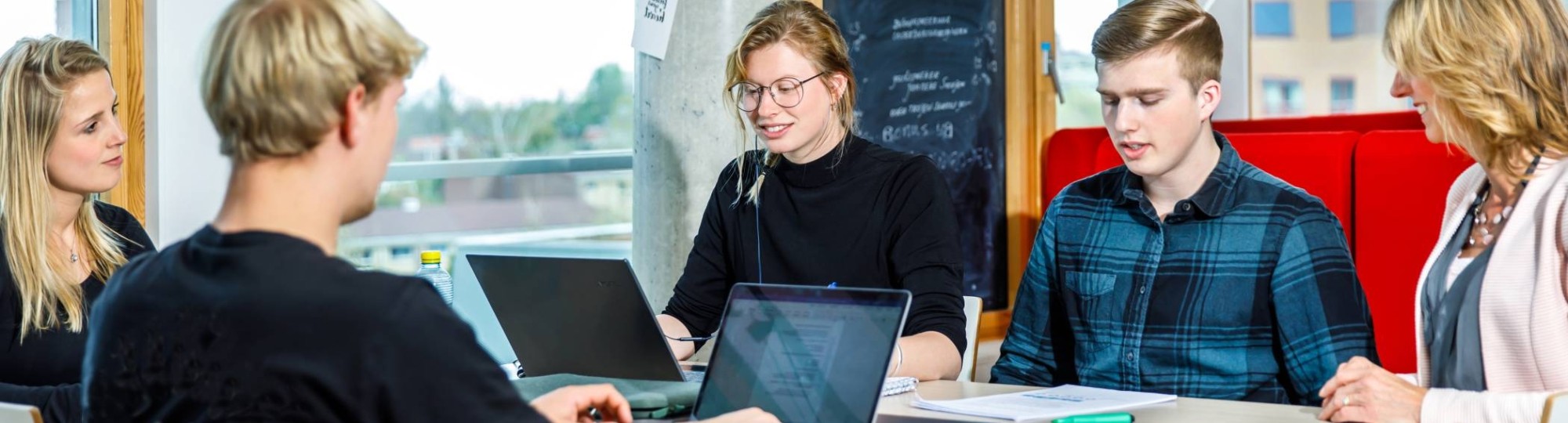 studenten aan hoge tafel met laptop. gespiegeld