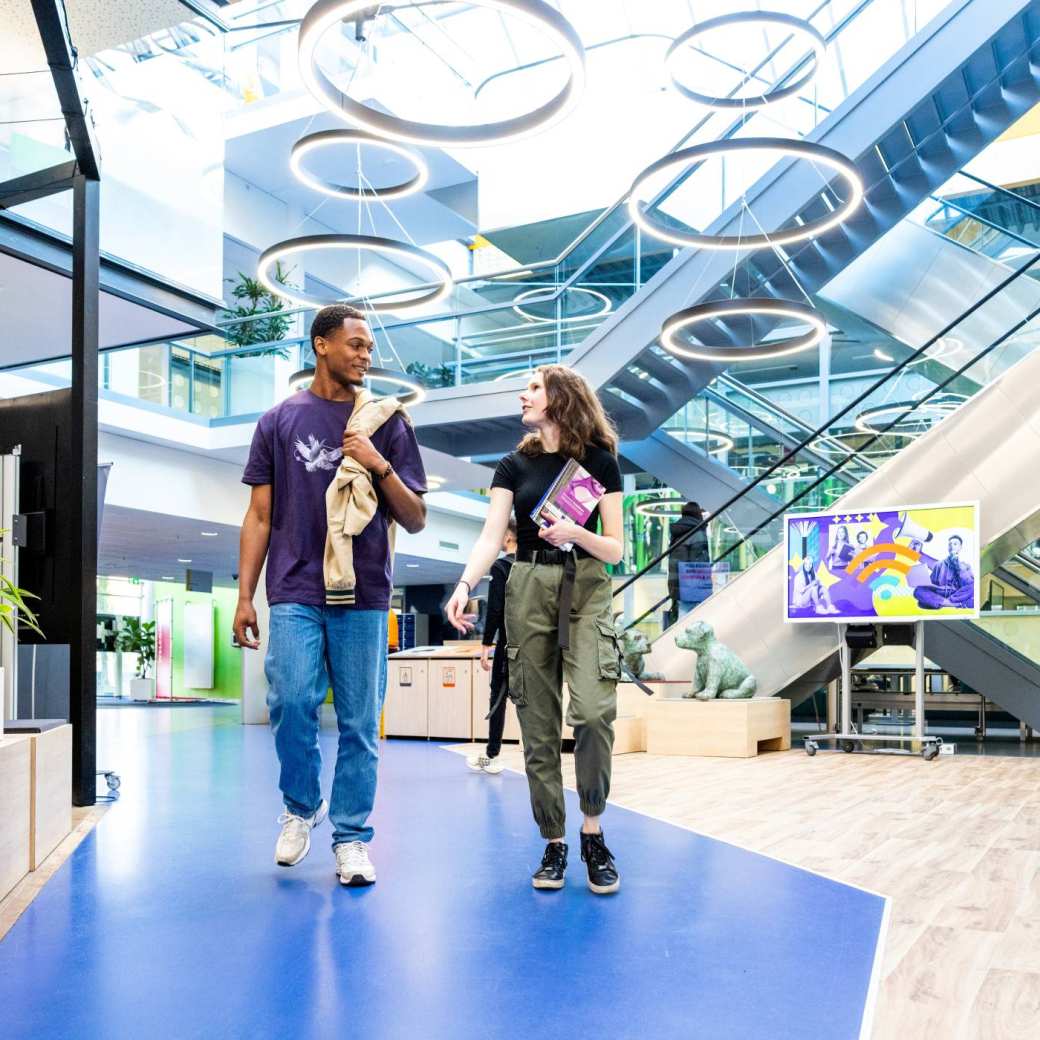 twee studenten lopen in de hal van de campus in Nijmegen