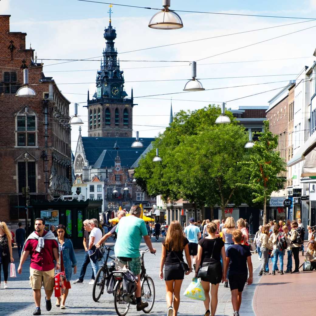 mensen in winkelstraat met kerk op achtergrond