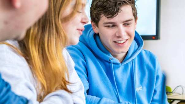 Foto van zijaanzicht van studenten die op de laptop zitten.