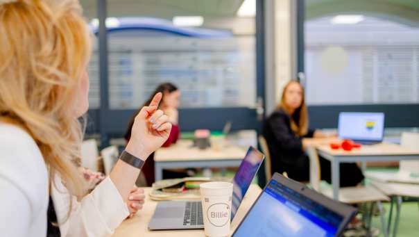 Deeltijd bachelor Commerciële Economie studenten in gesprek tijdens college.