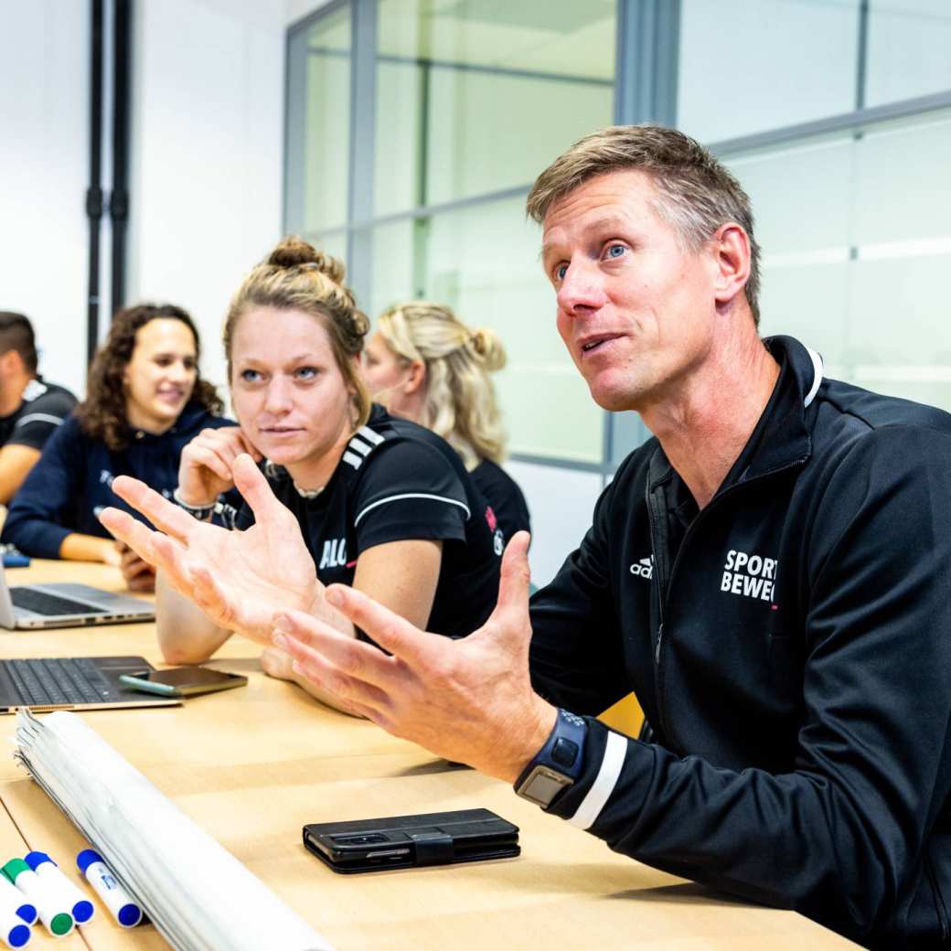 Docent legt uit in de les tussen studenten.