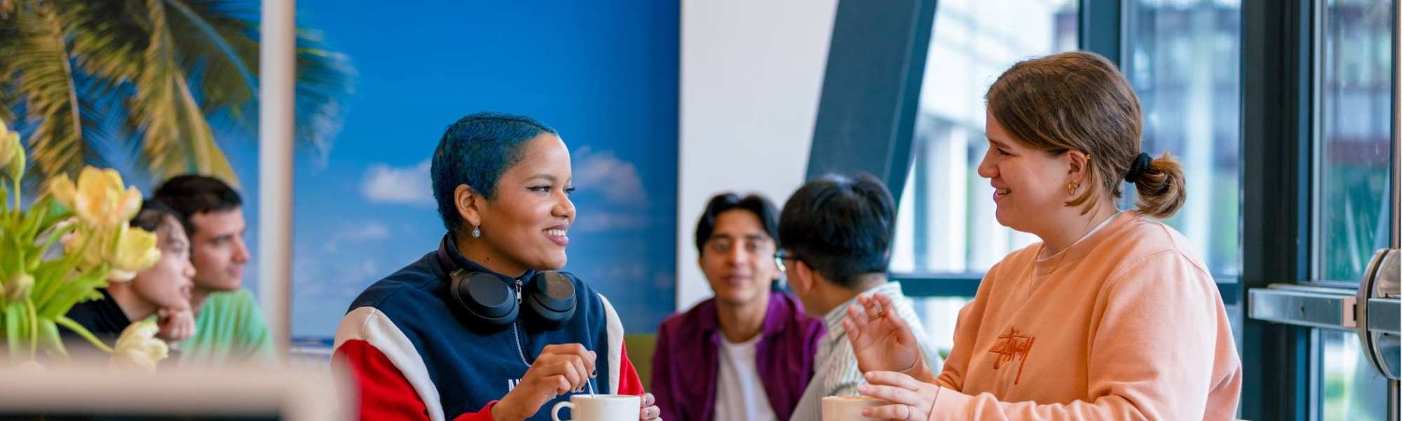 Students Noa, Chadionne, Tam, Diego, Nyugen and Andrei relaxing and drinking coffee in the Hangar on the Arnhem campus of HAN University of Applied Sciences.