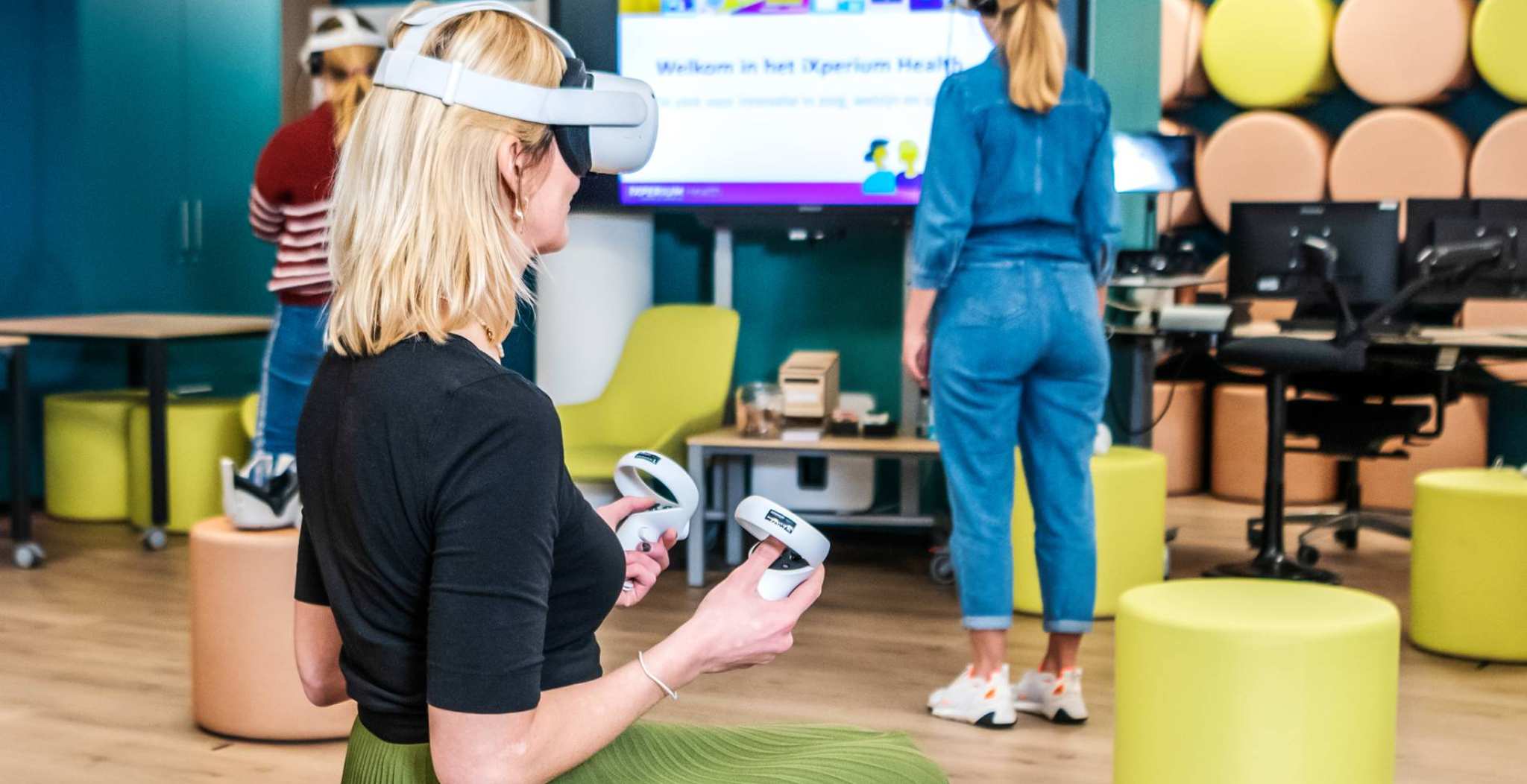 Foto van iXperium Health, waar 2 studenten en een docent een VR-bril op hebben.