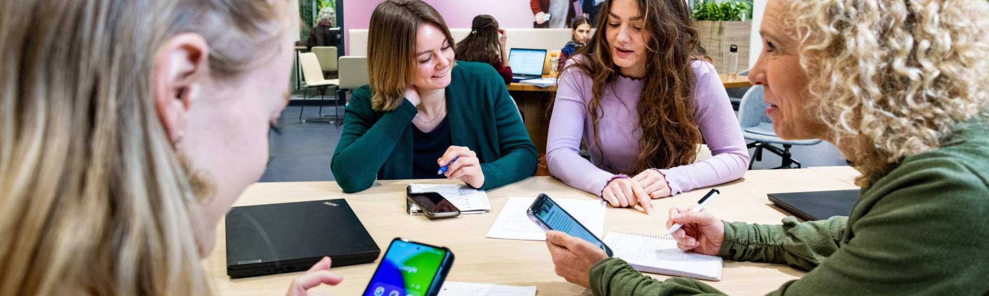 Studenten van Logistiek deeltijd zijn in overleg met hun telefoon