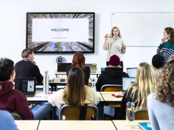 International Social Work. Klas college groep studenten en docent. digiboard op de achtergrond