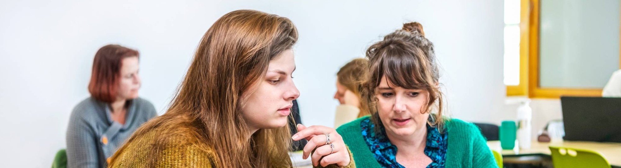 Twee studenten Leraar Engels werken samen op één laptop.
