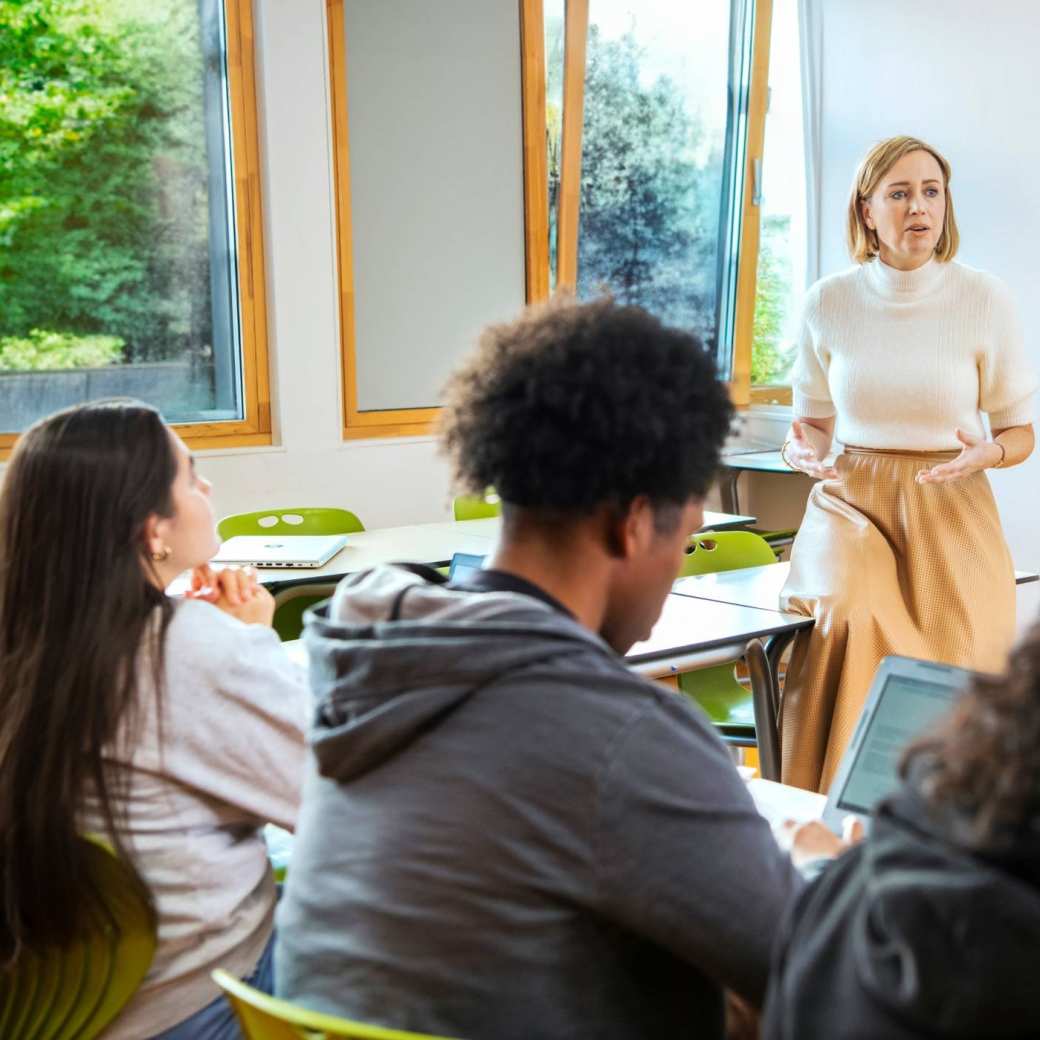 docent staat voor de klas en geeft uitleg