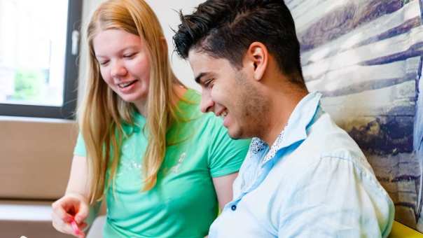 bedrijfskunde voltijd, foto 6620, studenten in gesprek op de bank met een boek