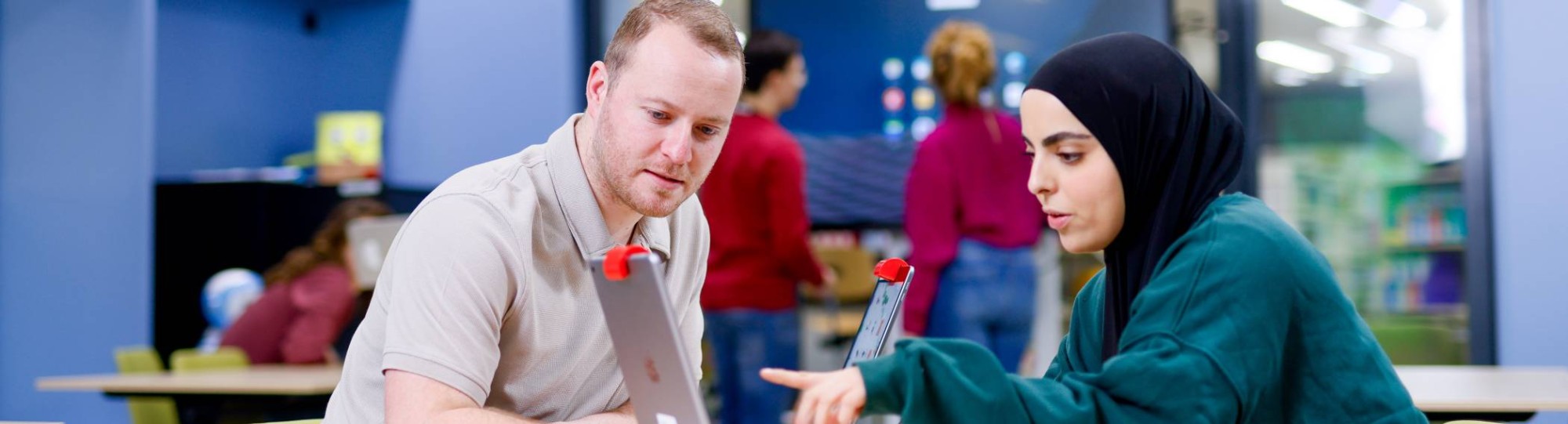 Studenten zitten in het iXperium en werken op een iPad