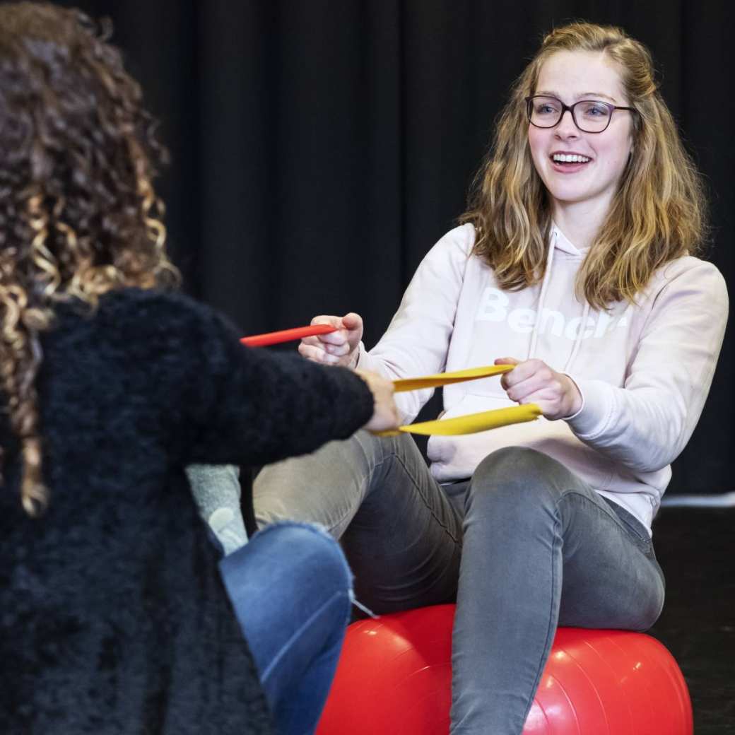 twee masterstudenten psychomotorische therapie doen een oefening met linten en ballen