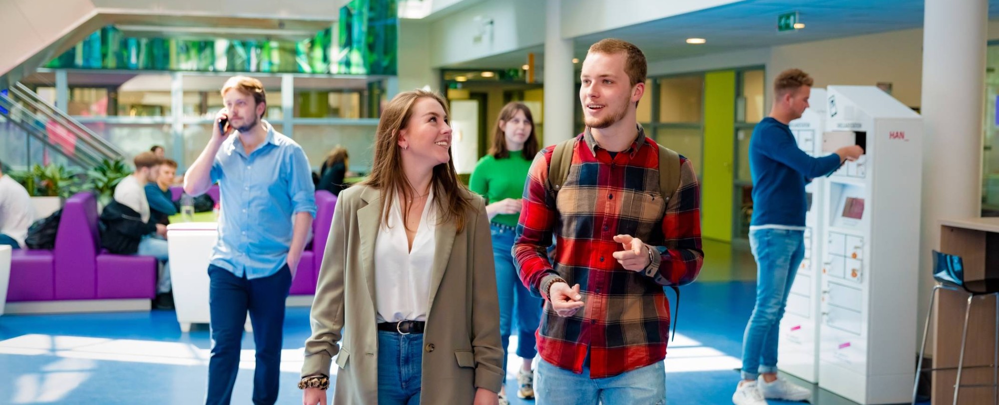 studenten van learning and development lopen door de gang in de HAN campus