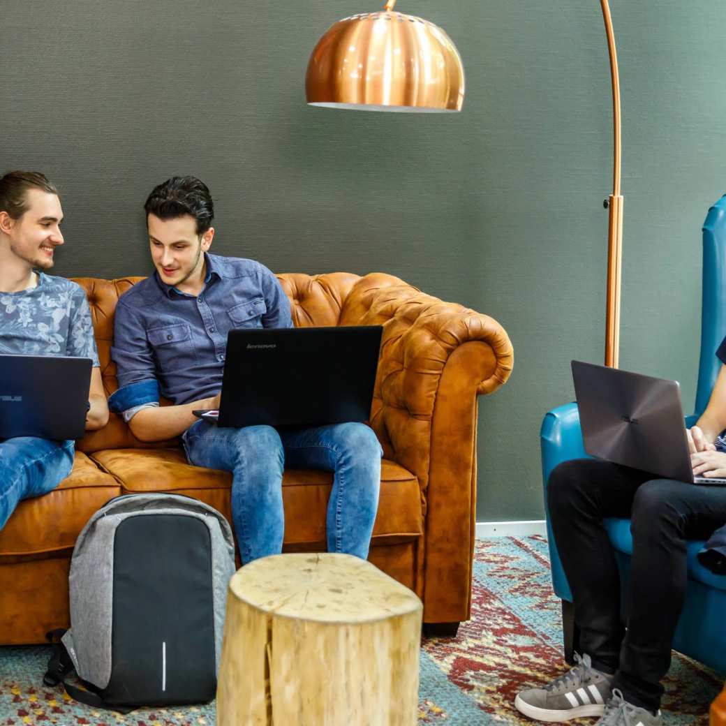 Drie jongens lachen en hebben plezier in huiskamer zitje