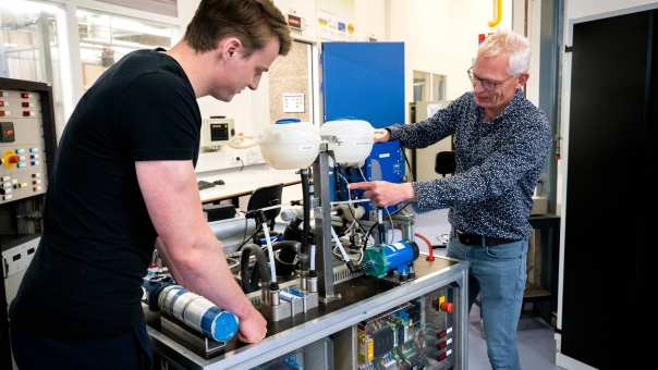 Een automotive docent en student werken samen aan de waterstoftafel.