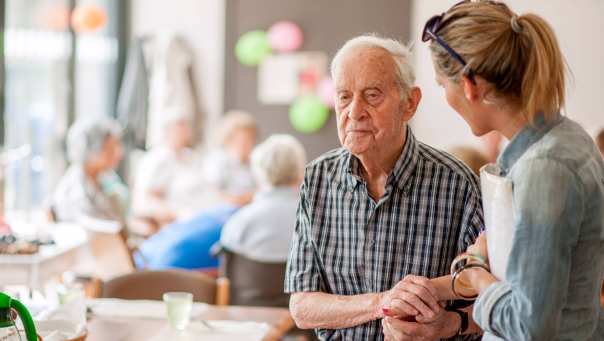 in het gemeenschapscentrum geeft advies aan oudere man