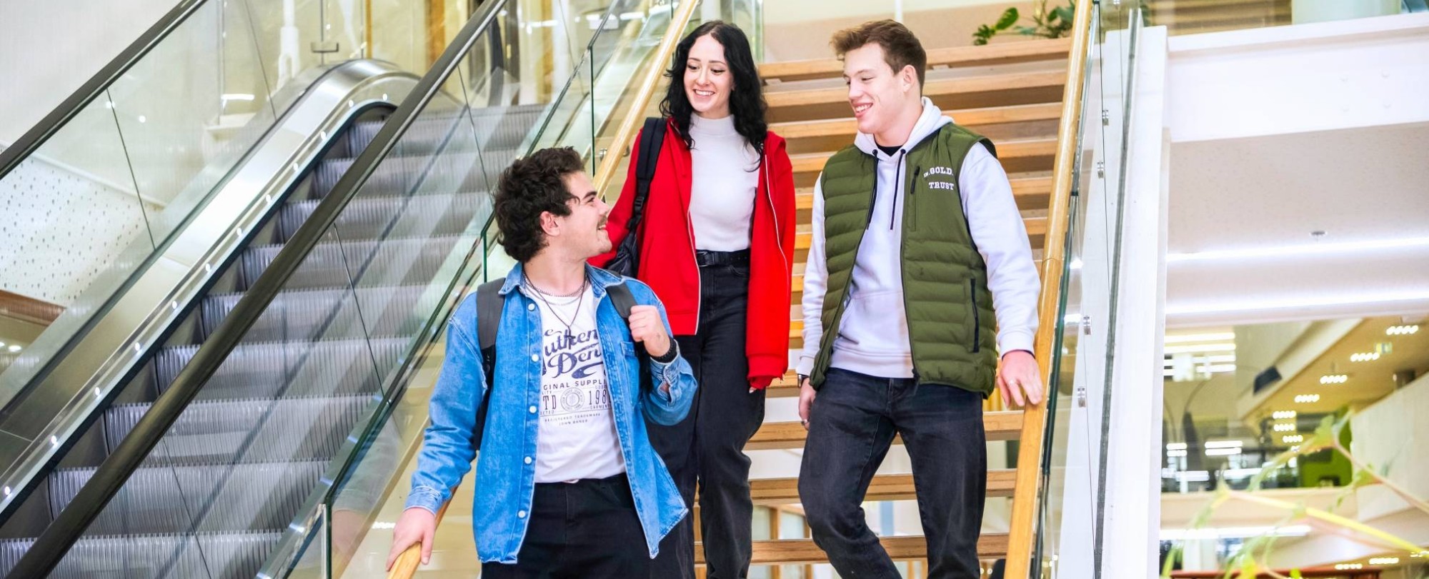 Drie studenten Leraar Natuurkunde lopen samen van de trap af.