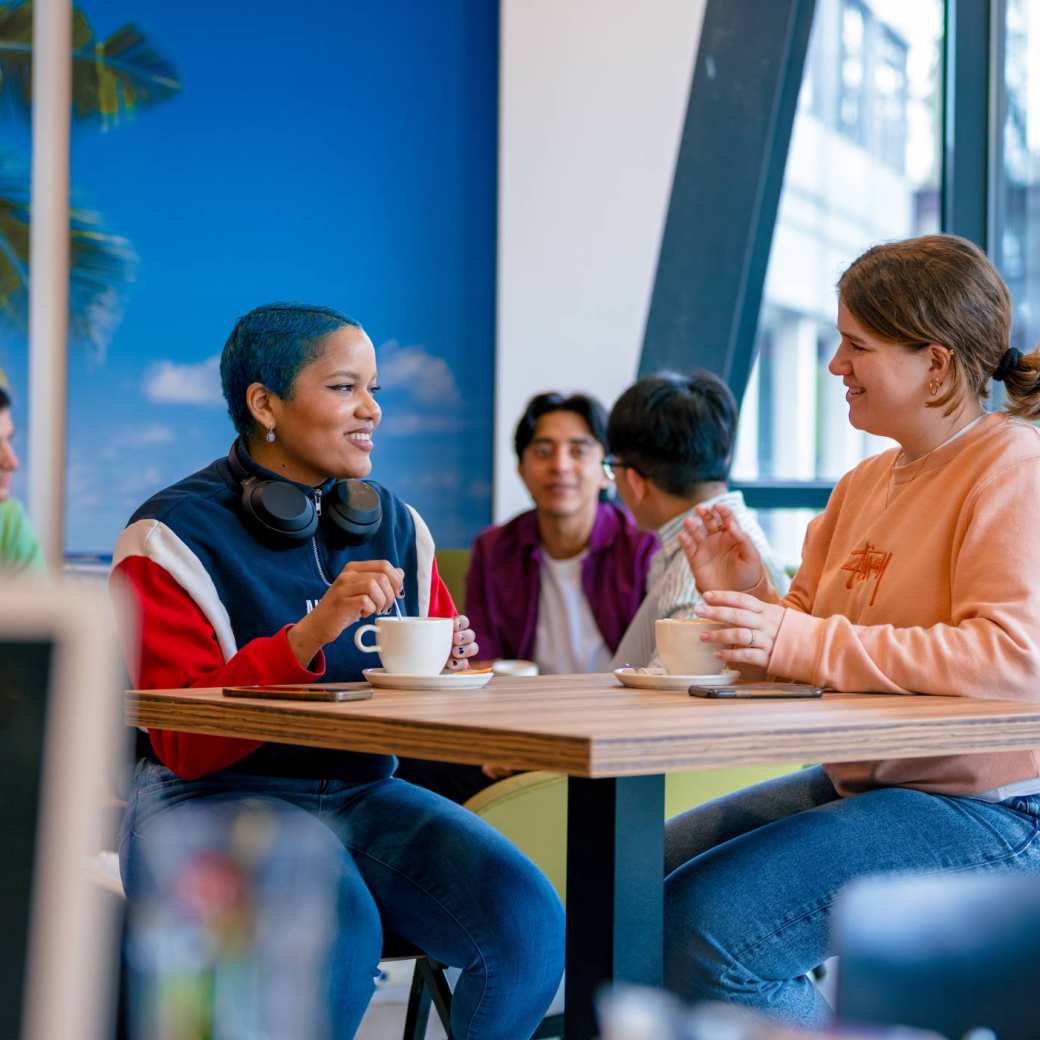 Students Noa, Chadionne, Tam, Diego, Nyugen and Andrei relaxing and drinking coffee in the Hangar on the Arnhem campus of HAN University of Applied Sciences.