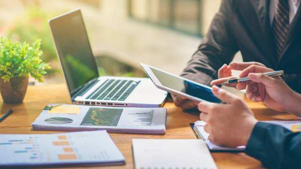 Stockfoto met laptop, papieren en financiën voor publicatie van het associate lectoraat Sustainable Finance & Tax van AFEM.