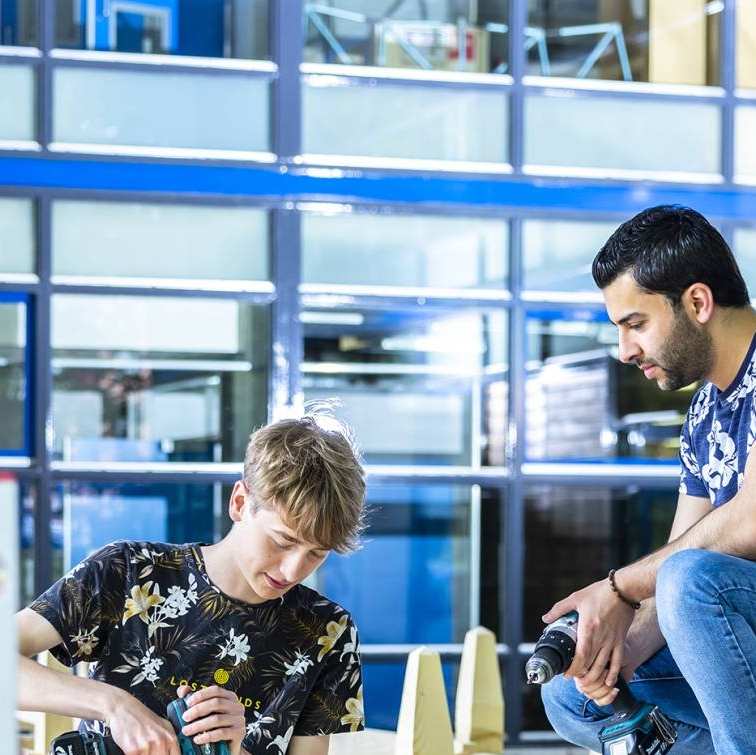 studenten werken aan een steiger onder het gebouw van de opleiding Civiele Techniek