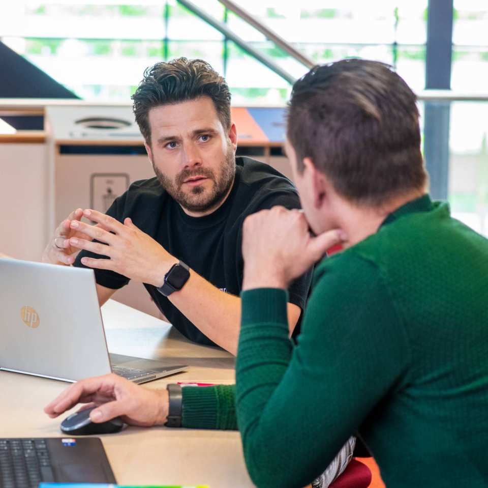 Twee studenten in gesprek met elkaar voor studie PMT deeltijd