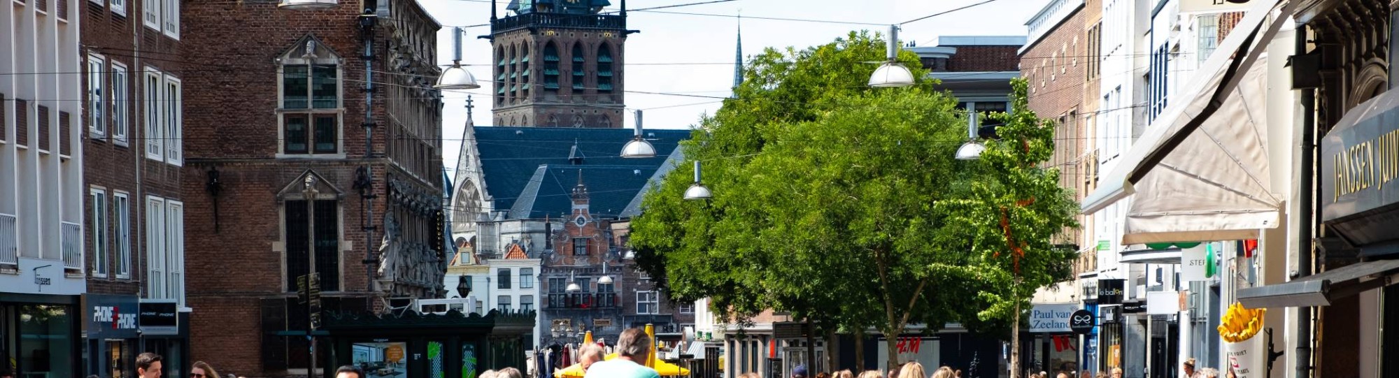 mensen in winkelstraat met kerk op achtergrond