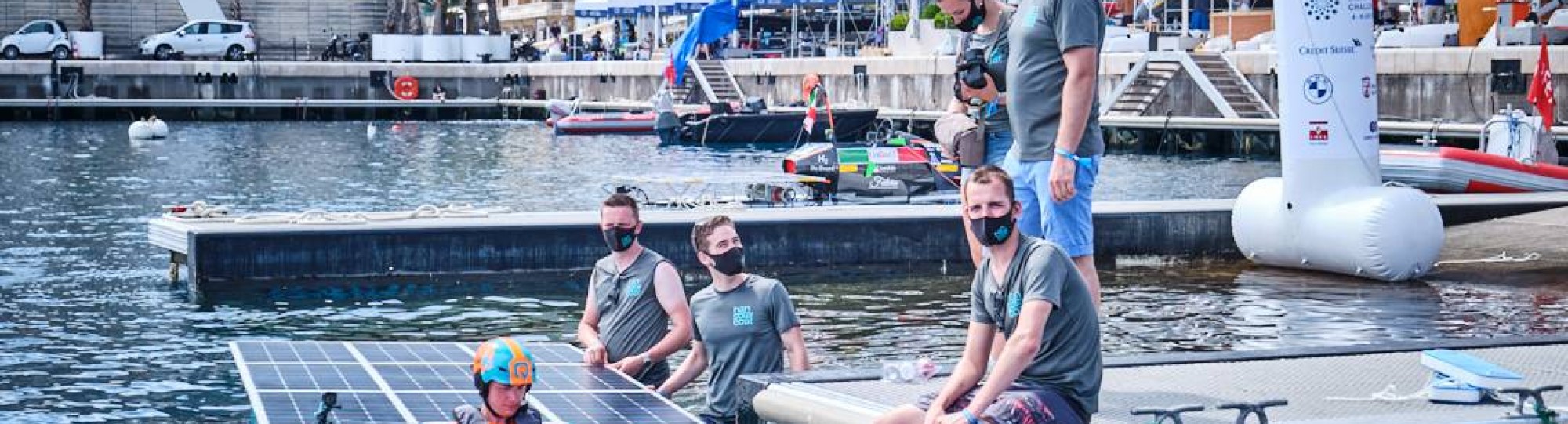 piloot van de solarboot is Mitchel. In het water staat links Rene en daarnaast Mik. Op de kant zit Remon en op de kade staan Leonie en Jurian. SEECE