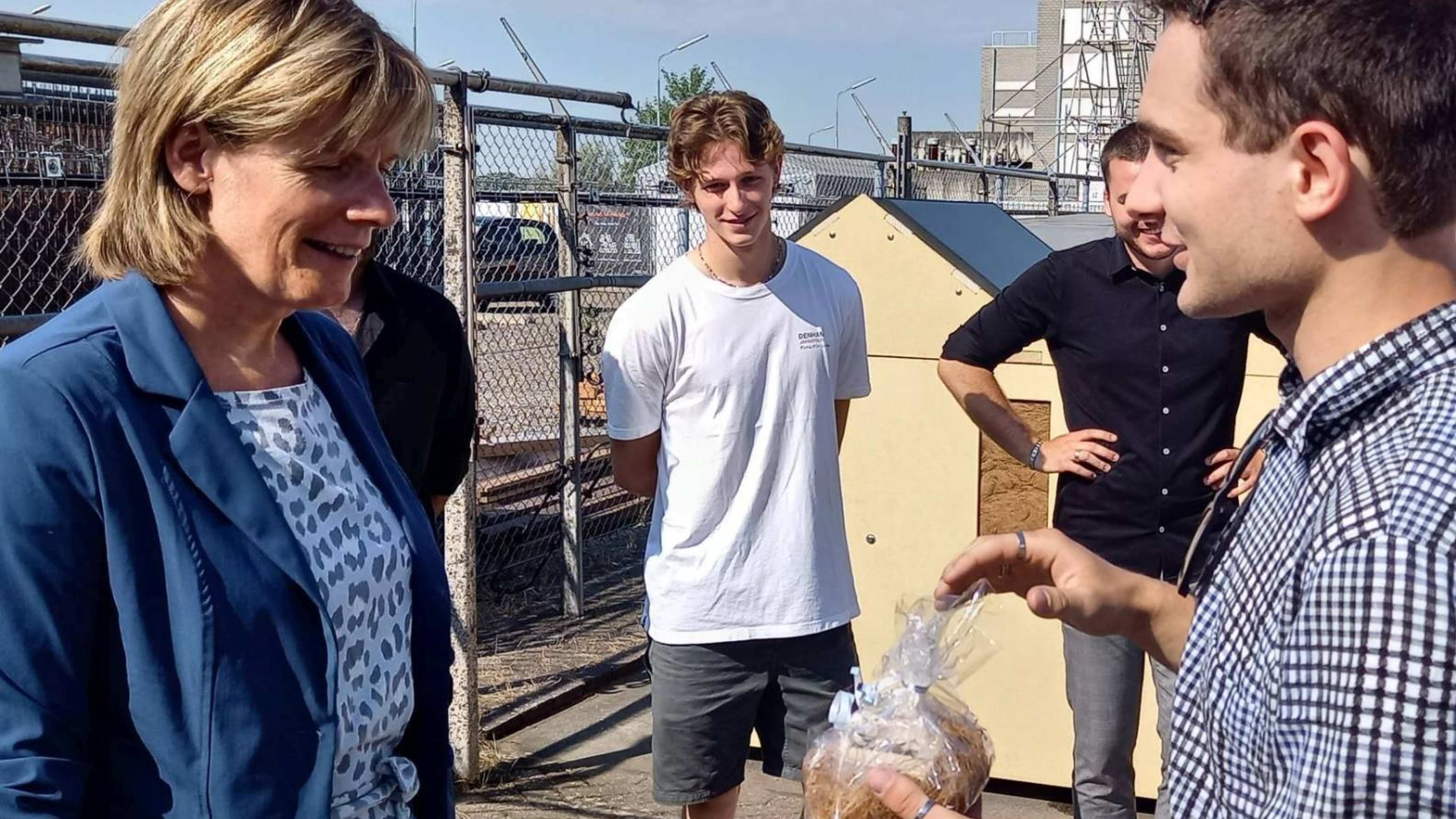 Gelders gedeputeerde Helga Witjes krijgt uitleg van Silas Teunissen, student Werktuigbouwkunde aan de HAN over de 3.0 versie van InfraWall, een modulair biobased geluidscherm.