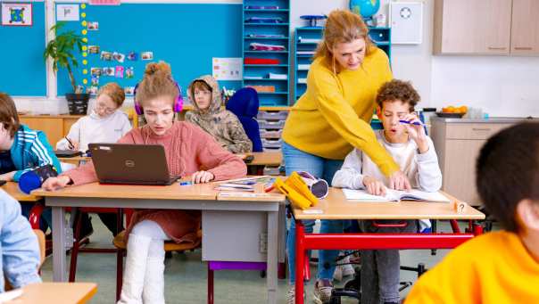 Speciaal Onderwijs op de school Lichtenbeek. De lerares wijst in een boekje van de leerling iets aan. 