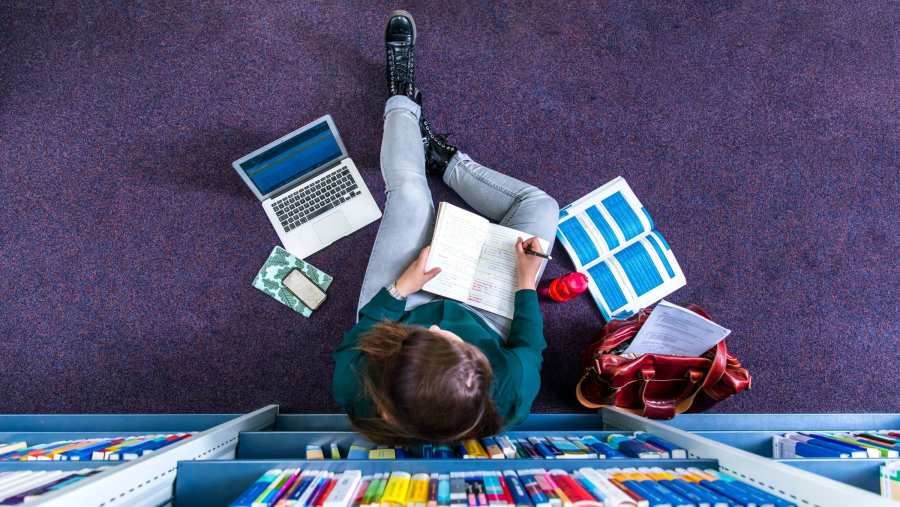 Studenten studeren in studiecentrum en maakt notitie, van bovenaf