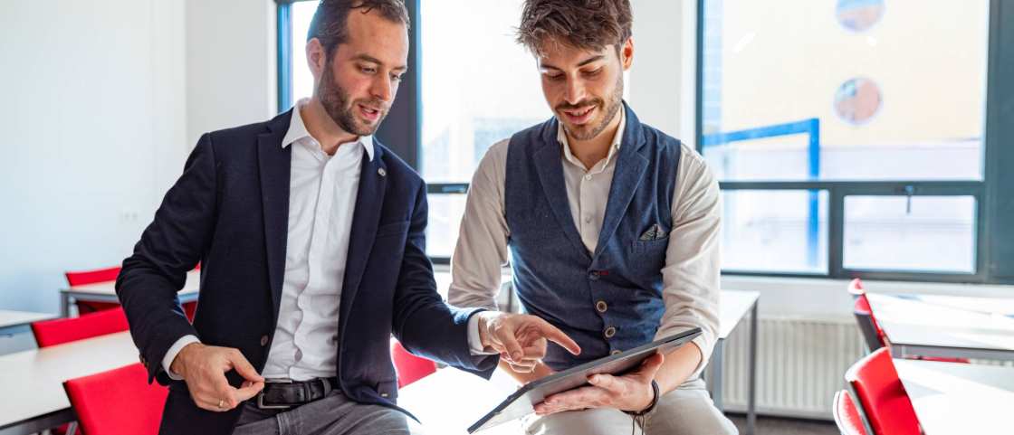 Twee projectleiders van het Centrum Meervoudige Waardecreatie zijn met elkaar in overleg, met een laptop in de hand.