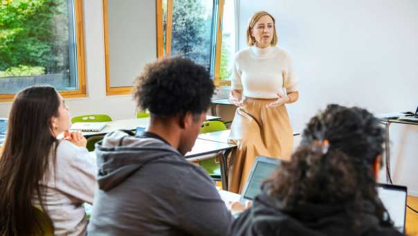 Een docent geeft les aan studenten masters economie.