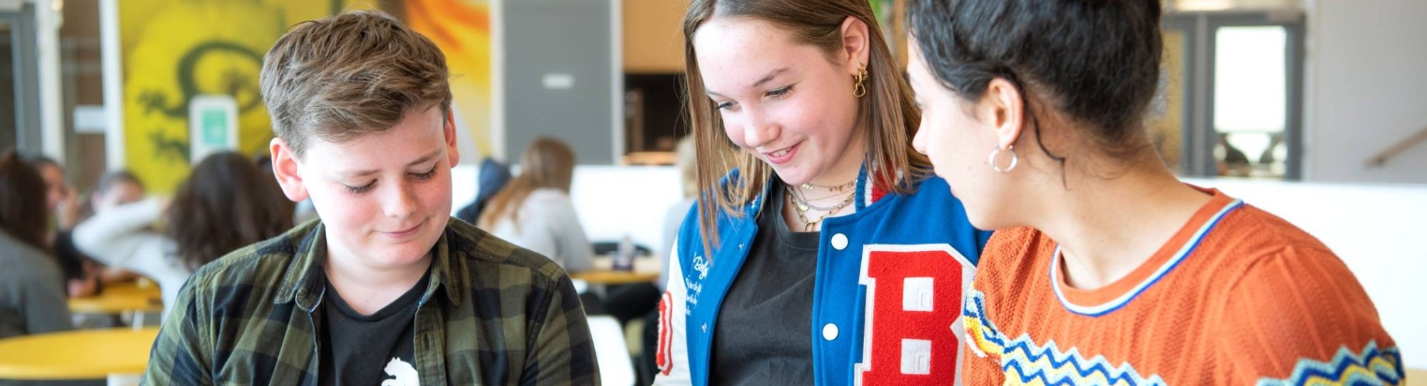 twee studenten in gesprek met docent aan tafel voor de fotoshoot van Leerlab bij Citadel 