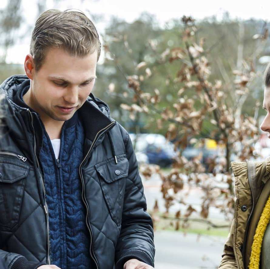 studenten op straat met kaartjes in hand