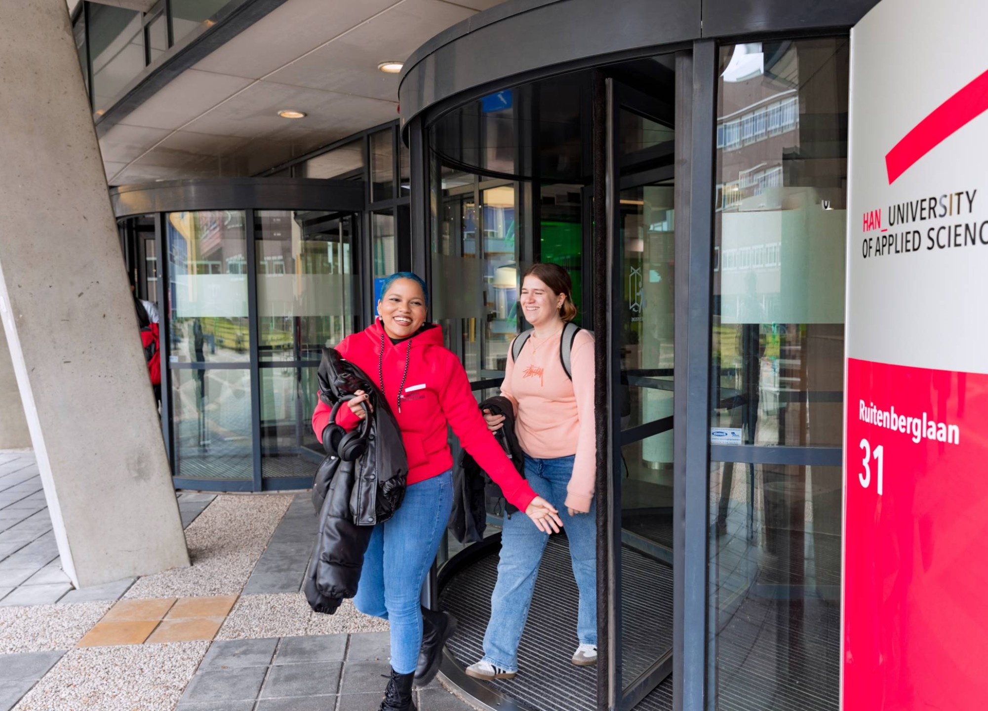 Noa and Chadionne walking through the entrance by Ruitenberglaan 31 HAN Arnhem campus.