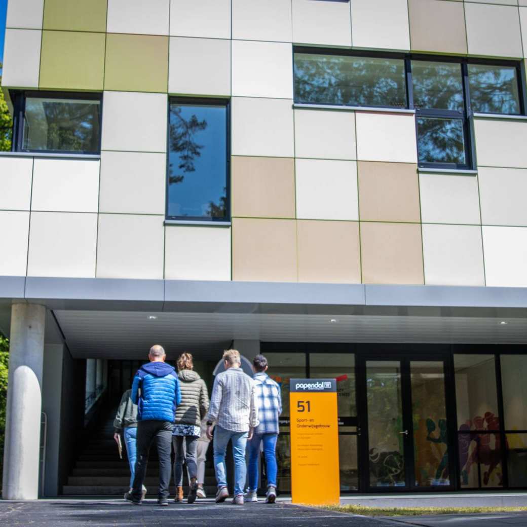 studenten lopen gebouw papendal in