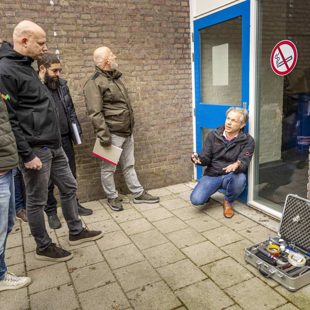 vastgoed inspecteur docent uitleg geknield bij kozijn